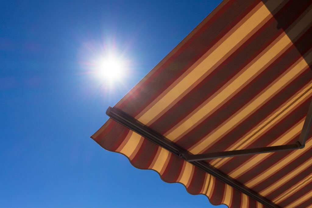 An extended retractable awning beneath a bright sun