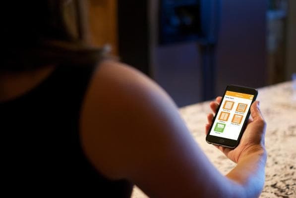A homeowner uses an app on their smart phone to check on the status of their awning with Smart Home Integration