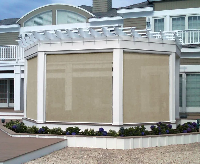 Beige motorized retractable screens enclosing a white pergola
