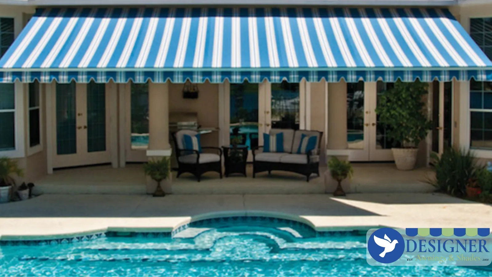 A blue and white striped retractable awning over a poolside patio