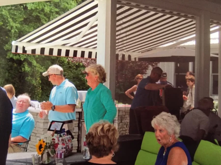 Guests gathering at an outdoor party under a retractable awning