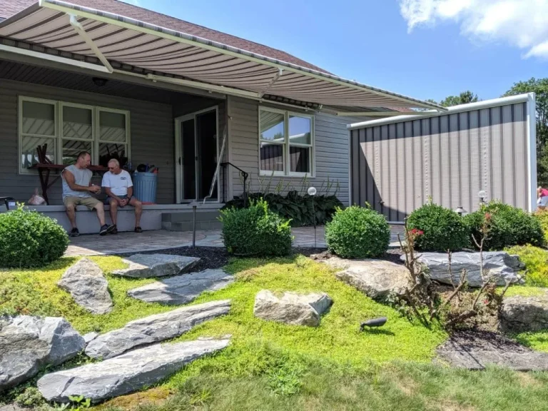 A retractable awning with a side screen shading a couple on a patio