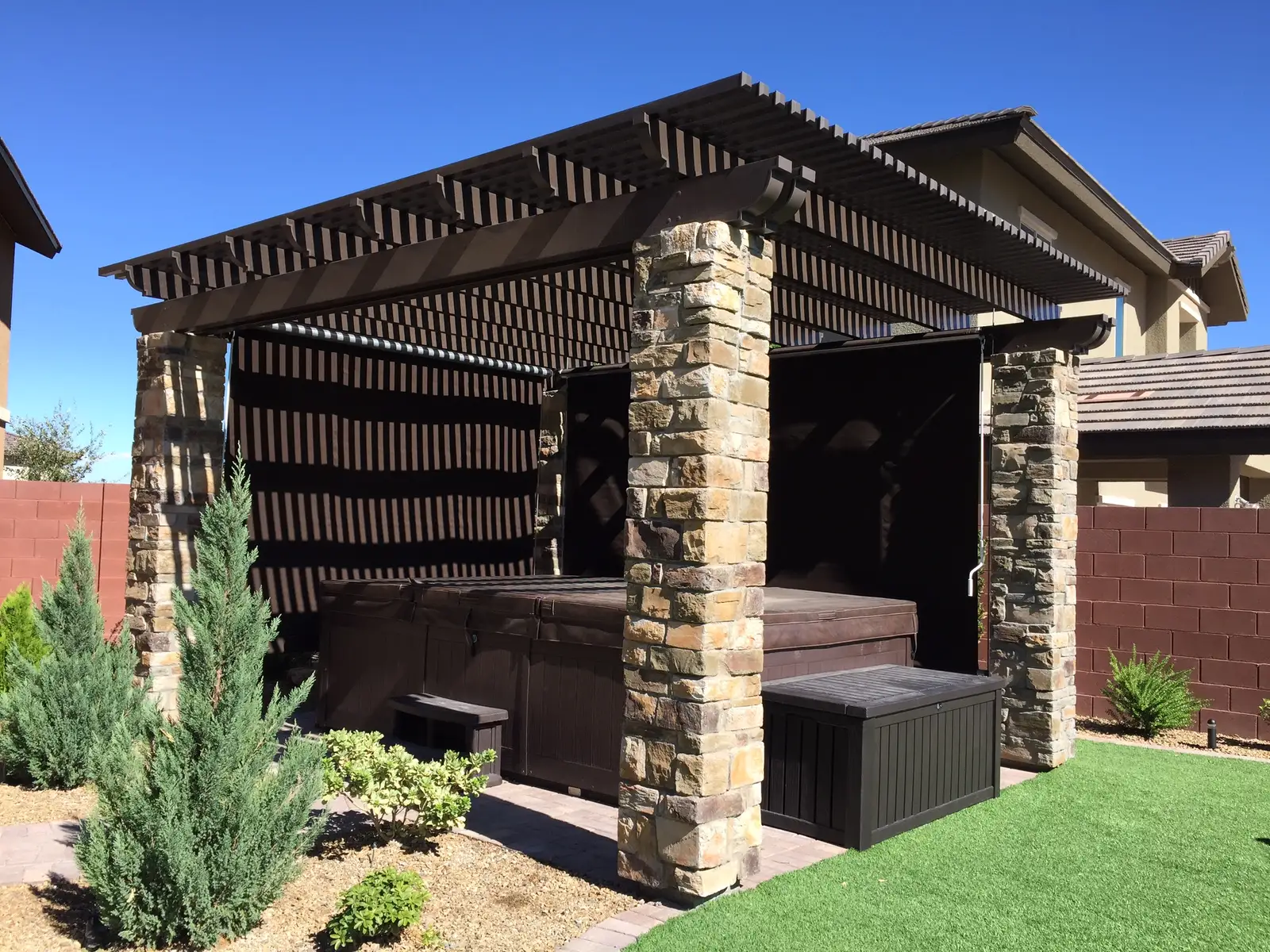A Sunesta shelter over a pergola with a hot tub