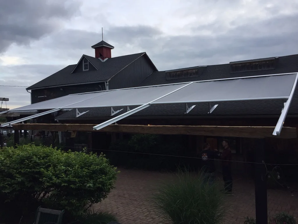 Dark retractable awnings over a restaurant patio