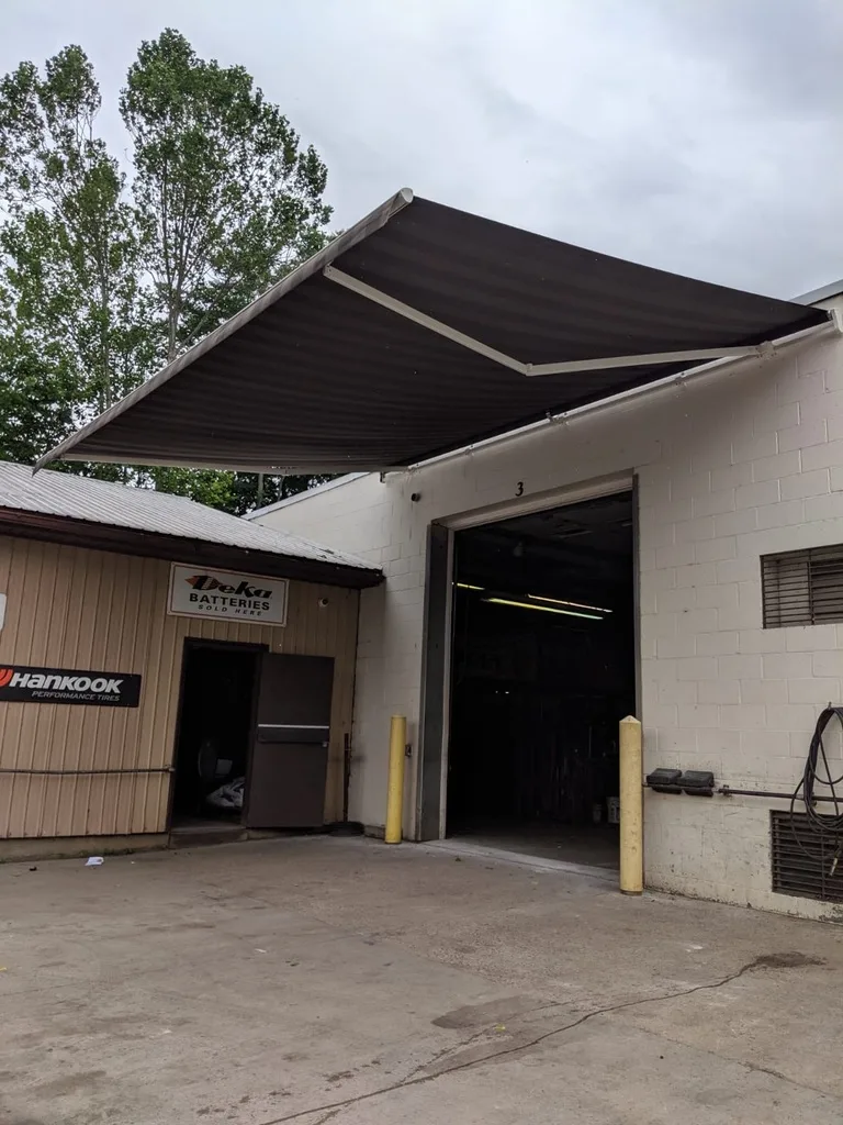 A dark retractable awning over the service bay of an auto shop