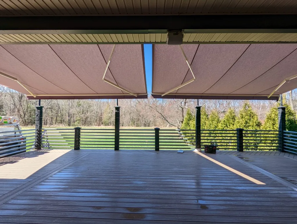 Two retractable awnings extended over a large commercial deck